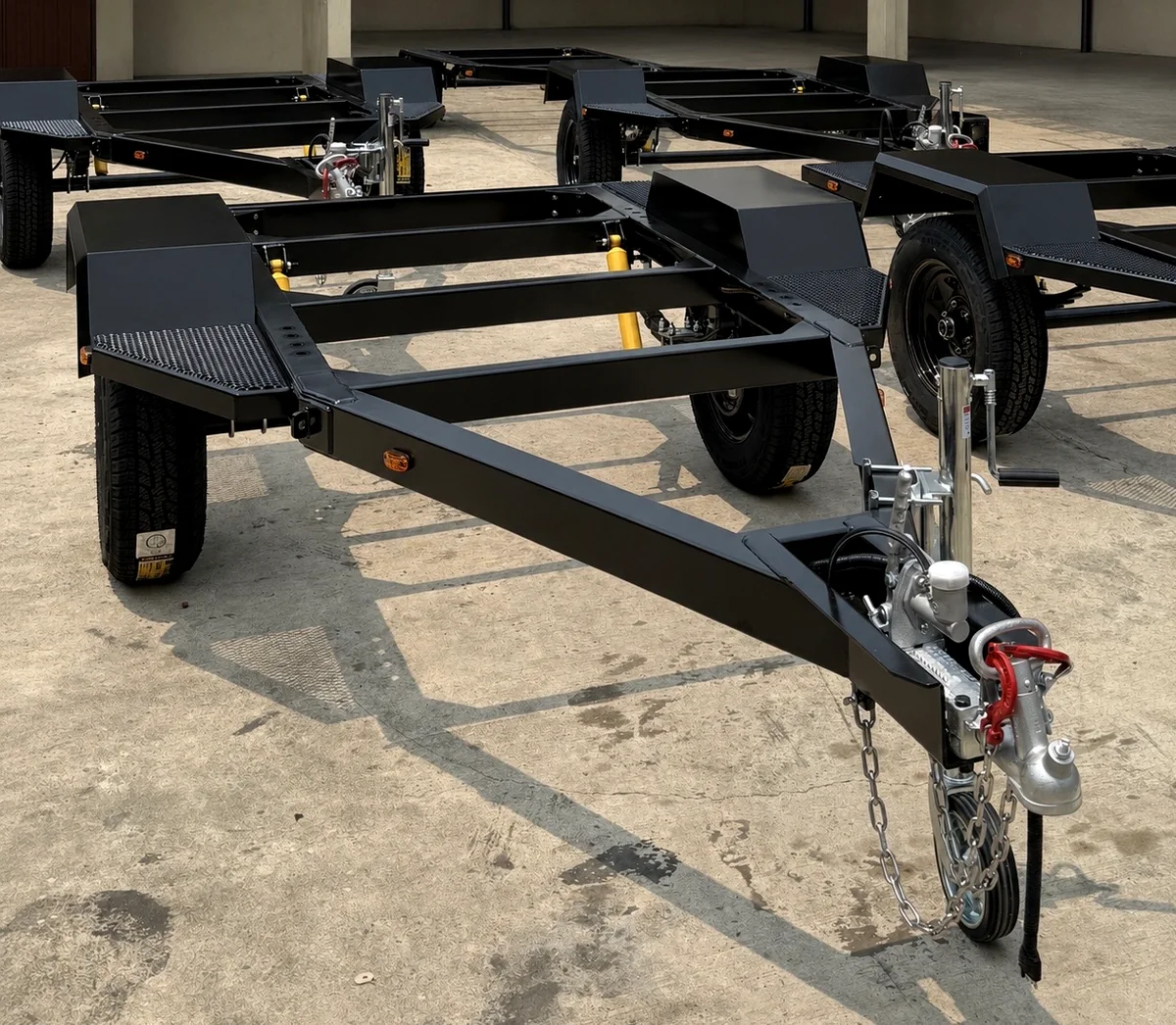 Ironwolf generator trailer chassis in the yard, showing the drawbar, coupler, jockey wheel, checker-plate step and torsion suspension