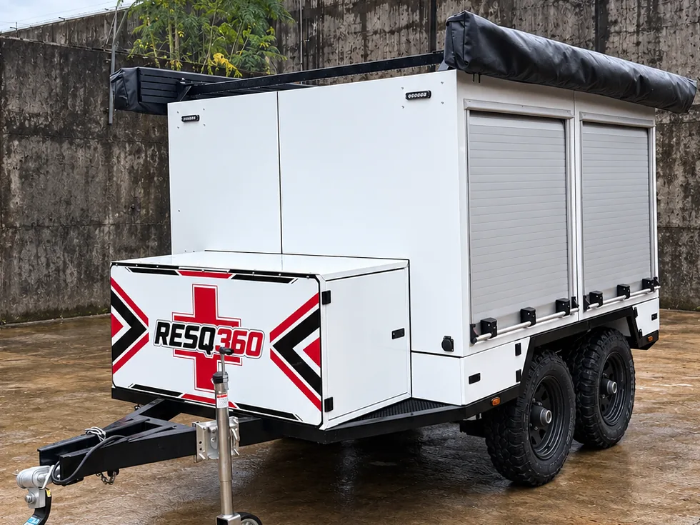 Front three-quarter view of the Ironwolf Rapid Rescue Platform in client RESQ360 livery, showing the deployed side awning, drawbar and jockey wheel